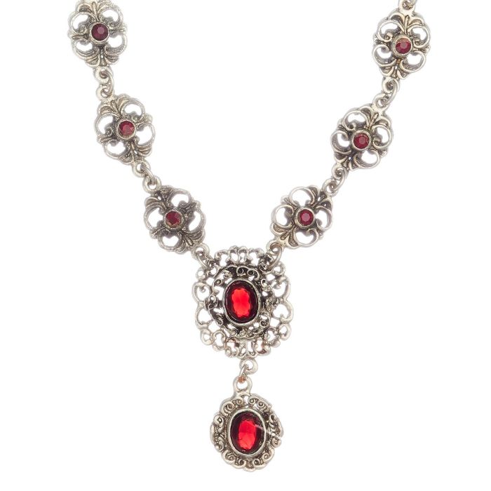 Silbernes Collier. Das Schaustück sind aneinandergereihte florale, blütenartige Elemente. Am unteren Teil sind ebenfalls floral wirkende Elemente, die rot leuchtende Farbsteine fassen. 