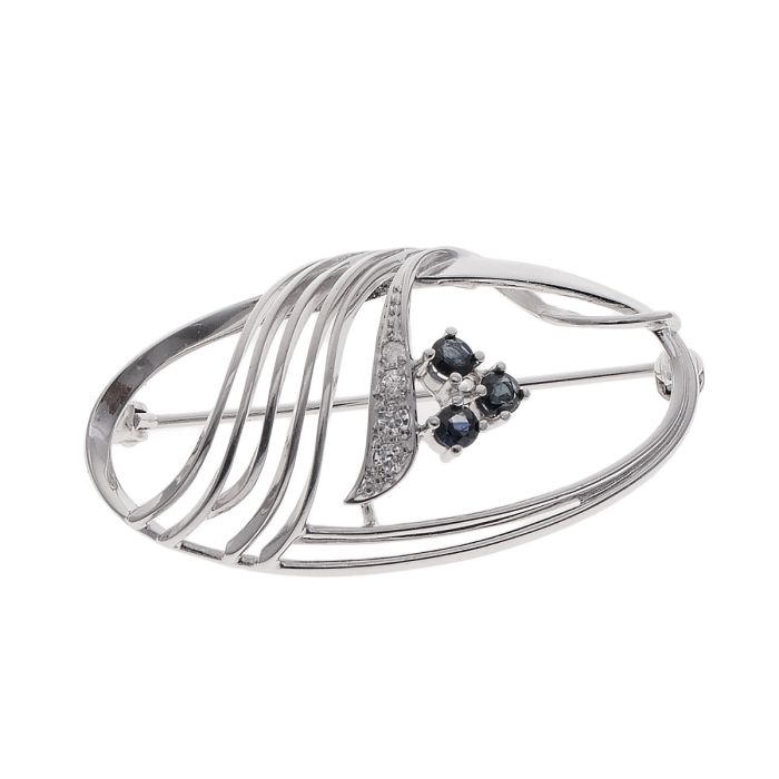 Silberne, filigrane Brosche mit 3 Saphir-Imitationen und 4 Zirkonia.
Geschwungene Linien führen durch die Brosche und lockern die schlichte Form elegant auf.