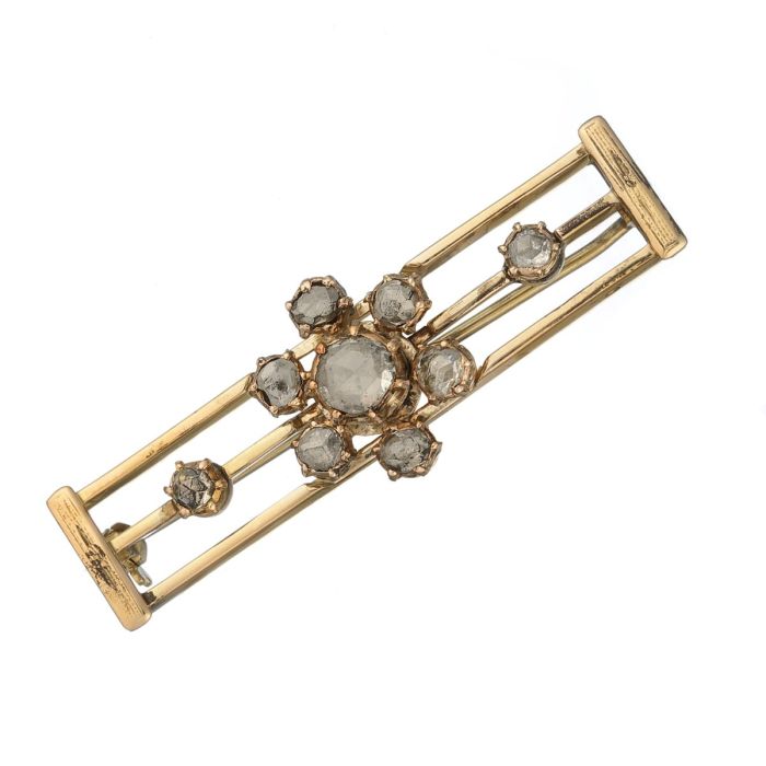 Handgearbeitete Jugendstil-Brosche als breite Stabnadel mit drei langen Vierkant-Stegen mittig besetzt mit Diamantrosen. Blütenförmig angeordnet und flankiert von je einem einzelnen Diamanten in Rosenschliff.