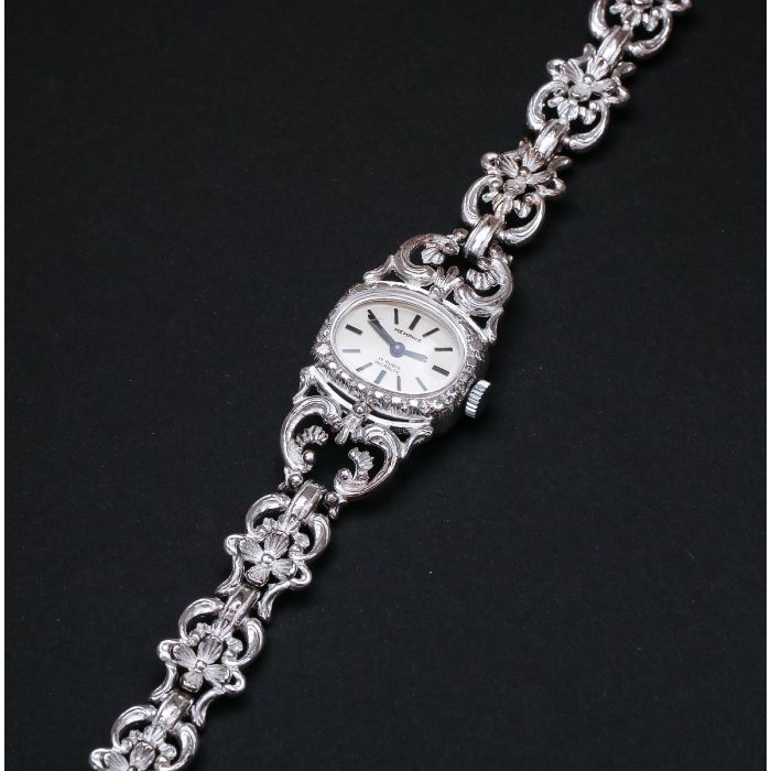 Damenarmbanduhr der Firma Memphis in 835er Silber Mit Handaufzug. In die geschwungenen Glieder des Armbandes sind kleine, filigrane Blüten eingearbeitet. 