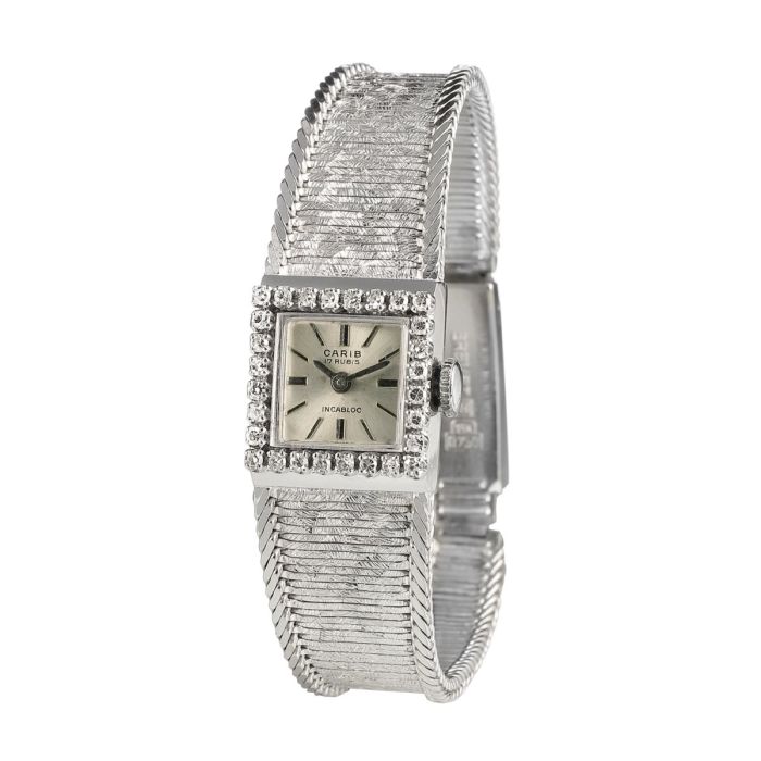 Damenuhr, CARIB / Schweiz mit viereckigem Gehäuse und diamantbesetzter Lünette von zus. ca. 0,30 ct., am Gehäuse verlötetes Schmuckband im Verlauf. Schauseitig mit „eismattierter Oberfläche“ seitlich eingefasst von je einem Strang in Fuchsschwanzgliederun