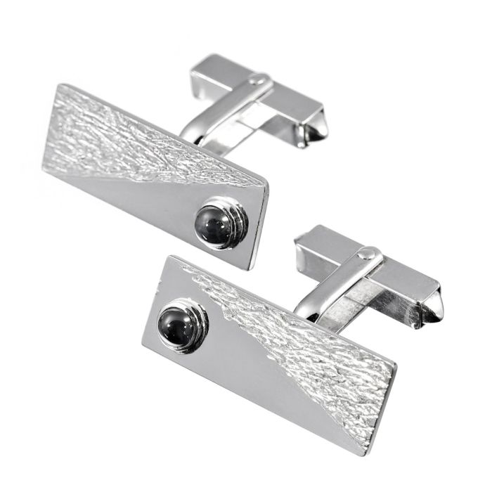Manschettenknöpfe in rechteckiger Form mit jeweils einem Saphir Cabochon besetzt. Die Schauseite der Manschettenknöpfe ist mit einem diagonal geteilten Muster gearbeitet. 