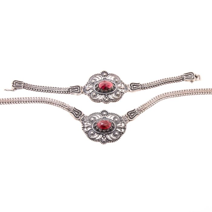 Set bestehend aus Collier und Armband. Das hübsche, florale Design der Schaustücke ist eine wirkliche Rarität. Mittig ist jeweils ein Granat in Rosenschliff gefasst.
Die Verschlüsse sind sehr dekorativ gearbeitet. 