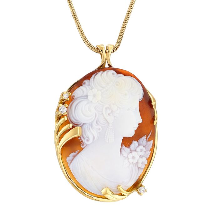 Anhänger inkl. Kette. 
Große Muschelkamee, die das seitliche Profil einer Frauenbüste mit Blütenkragen darstellt. Dieses ist in einer floral geschwungenen Fassung aus 18-karätigem Gold. mit 3 Brillanten. 
