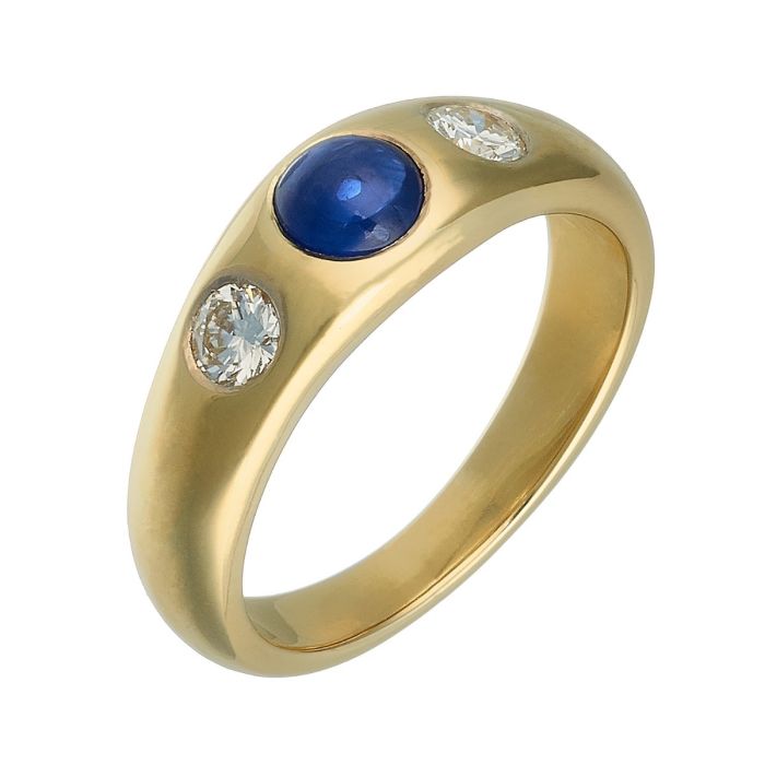 Bandring in 14-karätigem Gelbgold. Ein runder Saphir in Cabochonschliff, flankiert von 2 Brillanten, ist in eingeriebene Fassungen gearbeitet.