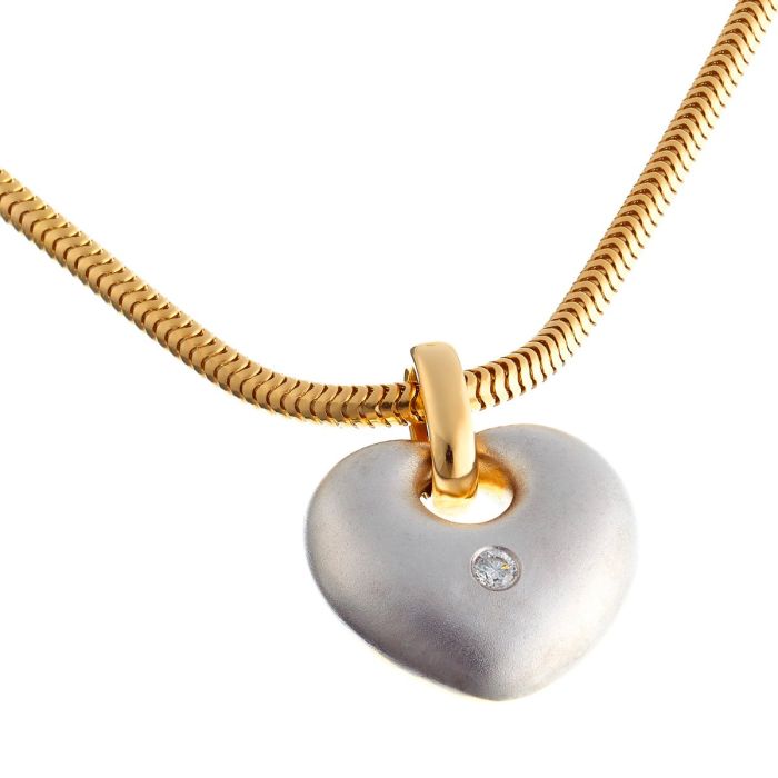 Moderner Anhänger in Bicolor.
Das herzförmige Schmuckstück ist auf einer Seite aus mattiertem Weißgold gearbeitet. Mittig ist ein Brillant mit 0,07 ct gefasst. Rückseitig ist der Anhänger aus poliertem Gelbgold. urchbrochene Elemente stellen 2 kleine Ele