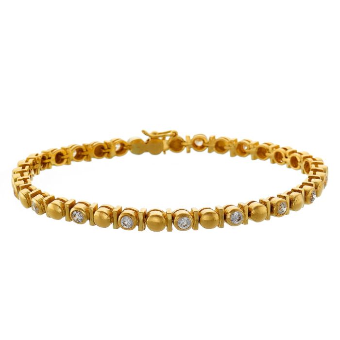 Armband in 14-karätigem Gelbgold. Die kugelförmigen Glieder sind durch kleine Stege als Zwischenelemente aufgelockert. Jedes 2. Element fasst einen Zirkonia. 