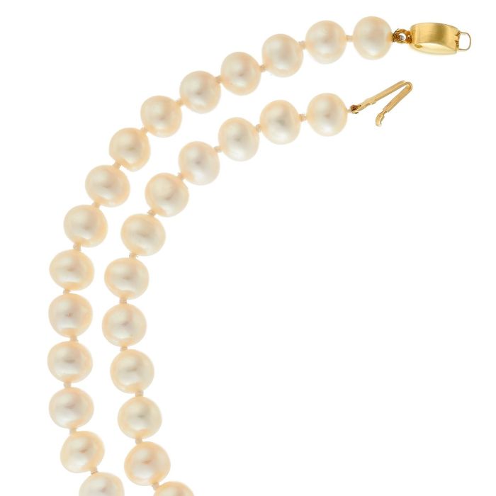 Einzeln geknotete Süßwasserperlenkette mit hellen Lüstern. Verschluss in 14-karätigem Gelbgold.