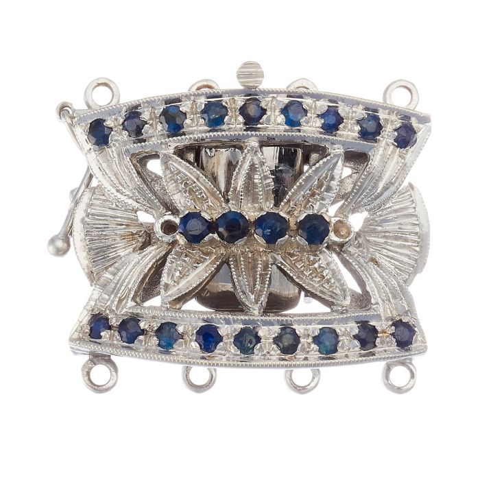 Perlkettenverschluss in 18-karätigem Weißgold. Das mittig floral gearbeitete Schmuckstück ist besetzt mit insgesamt 22 Saphiren, die am geschwungenen Rand und mittig verteilt thronen.