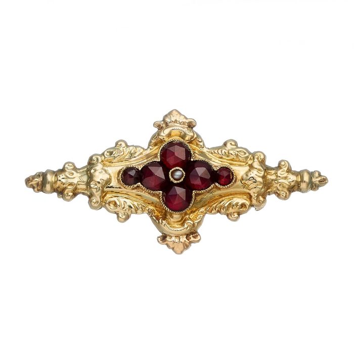 Antike Historismus-Brosche in 14-karätigem Gold. Die floral gestaltete kleine Brosche ist mit Dekorelementen des Rokoko geziert und besetzt mit 6 Granaten in Rosenschliff und einer Saatperle.