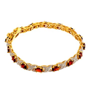 Armband aus vergoldetem Silber. 
Gekreuzte Gliederformen sind mit kleinen Diamanten besetzt. 
Zwischen den Gliedern ist jeweils ein Granat in Krabbenfassung.
Steckverschluss mit 2 Sicherheitsachten.