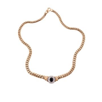 Gewölbte Flachpanzerkette mit von klein nach groß verlaufenden Gliedern und Karabiner-Verschluss. Mittig hat das Collier ein großes, ovales Schaustück, welches mit einem großen Saphir umgeben von 42 Brillanten mit ges. ca. 1 ct besetzt ist. 