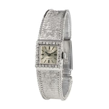 Damenuhr, CARIB / Schweiz mit viereckigem Gehäuse und diamantbesetzter Lünette von zus. ca. 0,30 ct., am Gehäuse verlötetes Schmuckband im Verlauf. Schauseitig mit „eismattierter Oberfläche“ seitlich eingefasst von je einem Strang in Fuchsschwanzgliederun