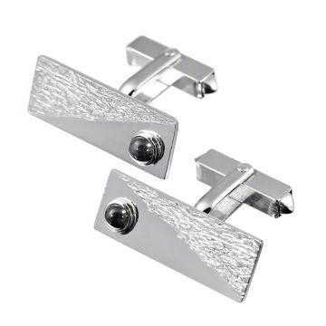 Manschettenknöpfe in rechteckiger Form mit jeweils einem Saphir Cabochon besetzt. Die Schauseite der Manschettenknöpfe ist mit einem diagonal geteilten Muster gearbeitet. 