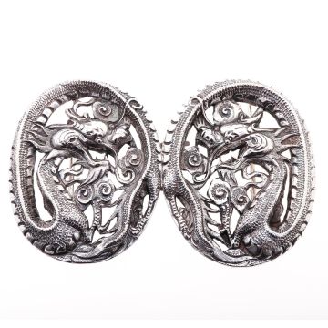 Chinesische Gürtelschnalle in 925er Silber. Ein Drachen ziert das Schmuckstück. Der Schwanz des Tieres bildet die ovalen Formen, indem er sich komplett um den Kopf und die phantasievollen Ornamente wickelt. 