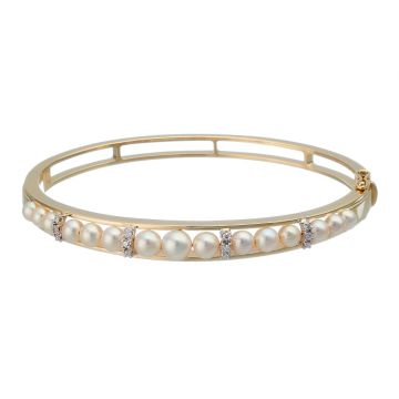 Armreif in 14-karätigem Gold. Schauseitig zieren insgesamt 15 Zuchtperlen den Armreif. Als Zwischenelemente dienen weißgoldene Krappenfassungen mit Diamanten.