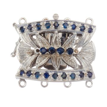 Perlkettenverschluss in 18-karätigem Weißgold. Das mittig floral gearbeitete Schmuckstück ist besetzt mit insgesamt 22 Saphiren, die am geschwungenen Rand und mittig verteilt thronen.