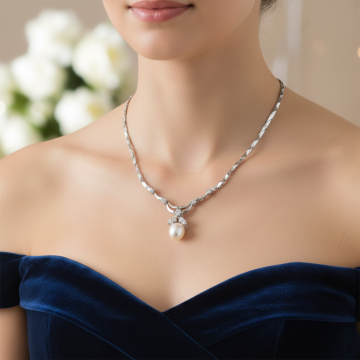 Collier in 14-karätigem Weißgold. Mit hochglanzpolierten Gliedern. Es hat 4 Diamanten gefasst. Am  Endstück zieren eine Zuchtperle, ein Brillant und 2 Diamanten das Schmuckstück.  