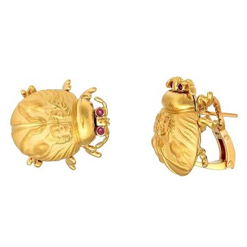 Massive Ohrstecker aus 18-karätigem Gelbgold in Form von Skarabäus. Der Korpus der Tiere ist mattiert, während Beine und Kopf hochglanzpoliert sind. Die Augen sind mit Rubinen besetzt.