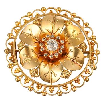 Jugendstil-Brosche in Form einer Blüte, mittig besetzt mit einem Altschliffbrillanten in Krappenfassung entouriert von kleinen Diamantsplittern in Zargenfassungen als Blütenstempel.
