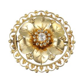 Jugendstil-Brosche in Form einer Blüte, mittig besetzt mit einem Altschliffbrillanten in Krappenfassung entouriert von kleinen Diamantsplittern in Zargenfassungen als Blütenstempel.