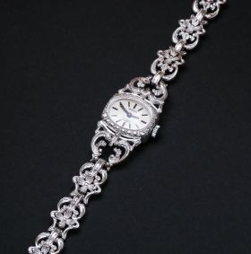 Damenarmbanduhr der Firma Memphis in 835er Silber Mit Handaufzug. In die geschwungenen Glieder des Armbandes sind kleine, filigrane Blüten eingearbeitet. 