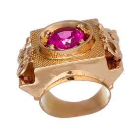 Unisex-Ring. Das Schaustück des Ringes ist kantig gearbeitet und fasst mittig einen Rubin als Imitation auf einer eckigen, ziselierten Platte. 